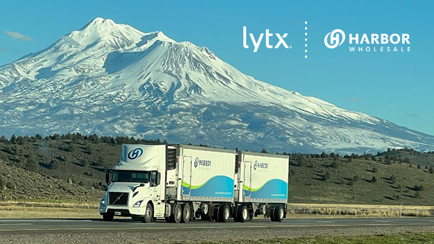 semi truck and trailer on highway with snowy peak in background
