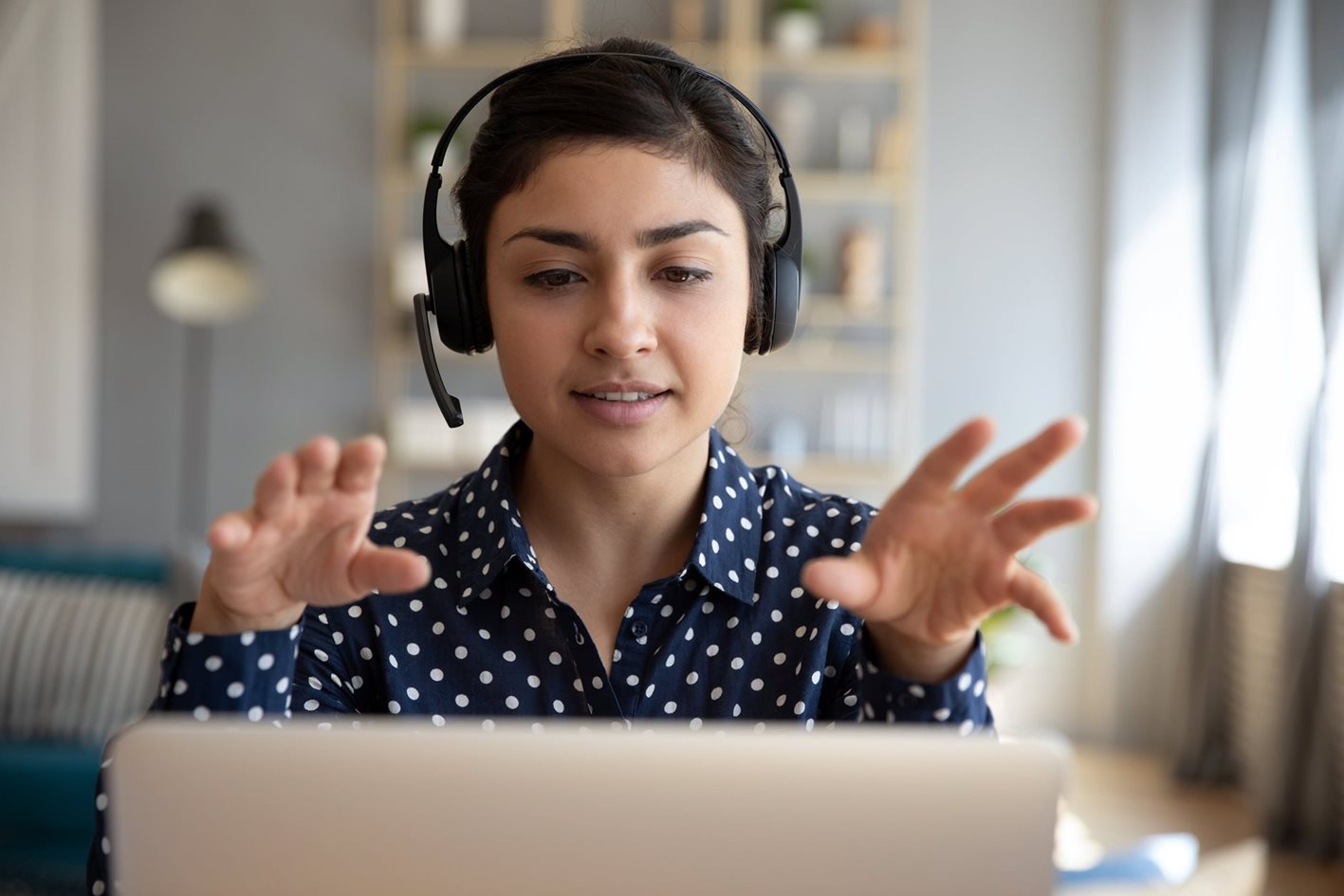 Fleet manager wearing a head set sitting in front of a laptop appearing to speak with someone through the headset