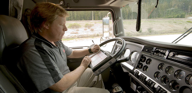 driver sitting in vehicle filling out paper ELD form