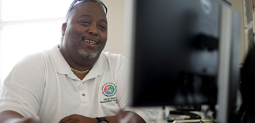 someone smiling while looking at a computer