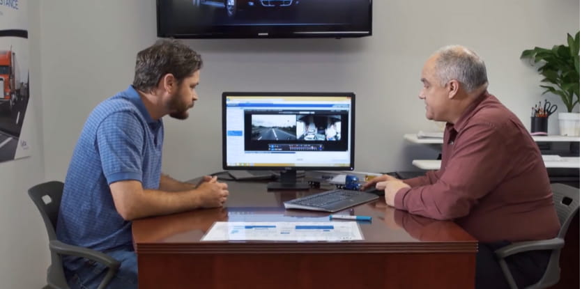 coach and driver looking a video on a computer