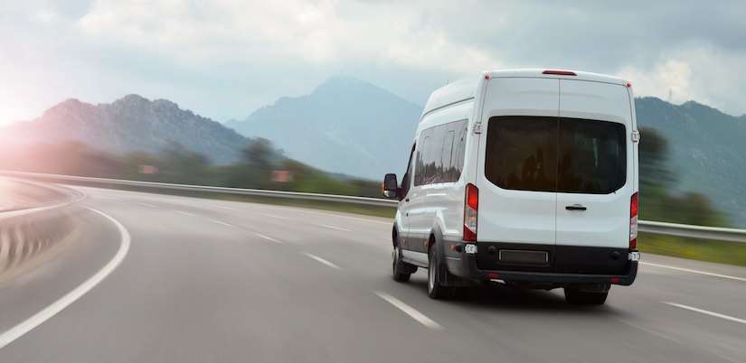 white van driving down the road