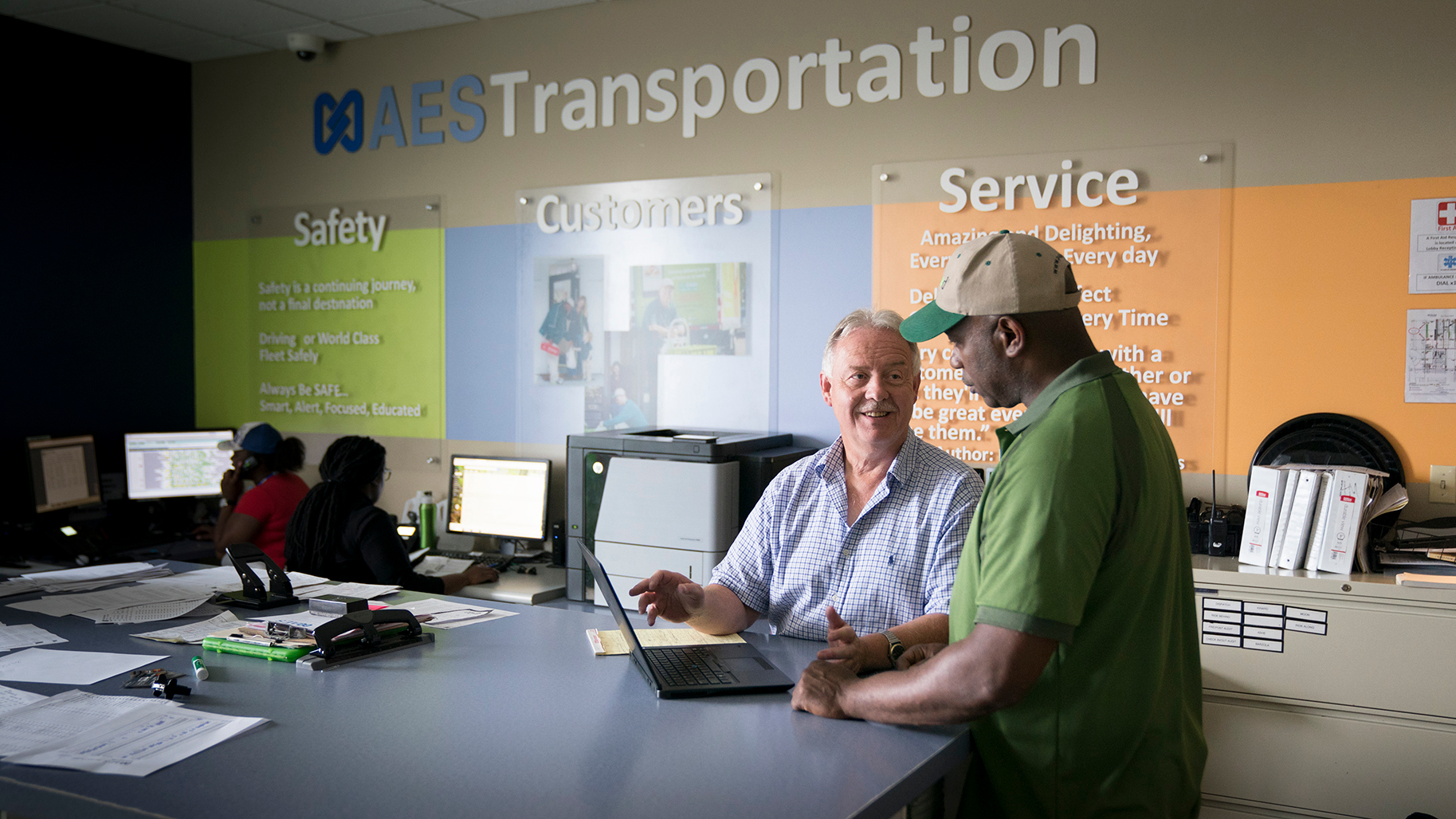 coach and driver looking a video on a computer