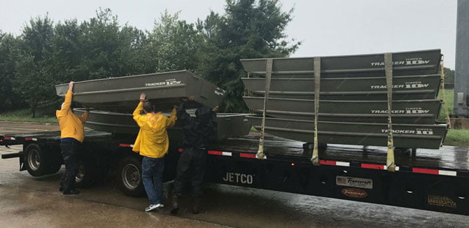 3 people loading things onto a flatbed