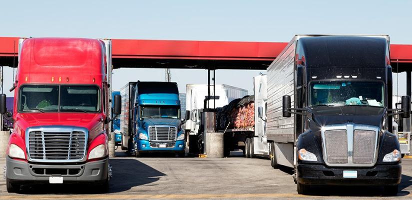 multiple long haul trucks at a gas station