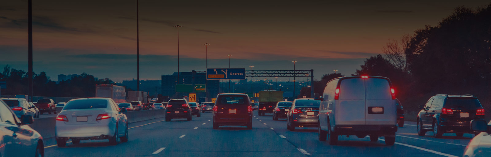 congested freeway with vehicles showing brake lights at sunset